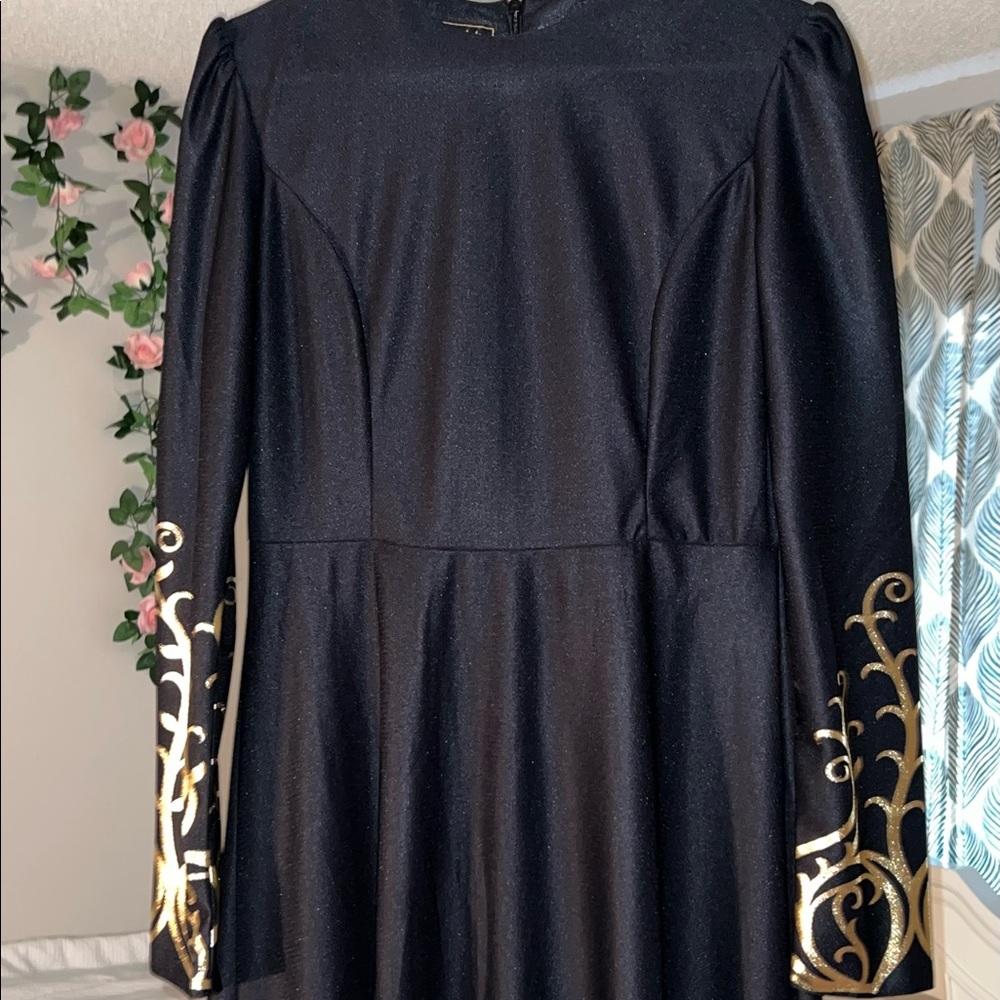 I am selling a black high-low dress with gold accents.